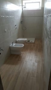 seconda immagine del bagno in fase di ultimazione. Fornitura e posa dei sanitari in appoggio in ceramica bianca, fornitura e posa pavimento in  gres porcellanato 